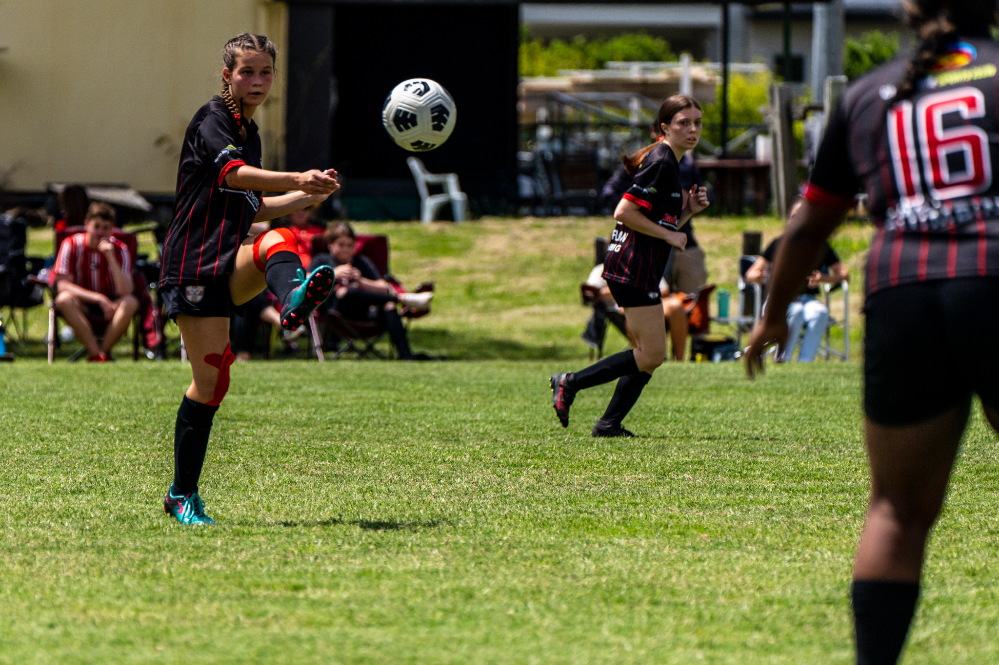 Women's football match with a player about to strike the ball