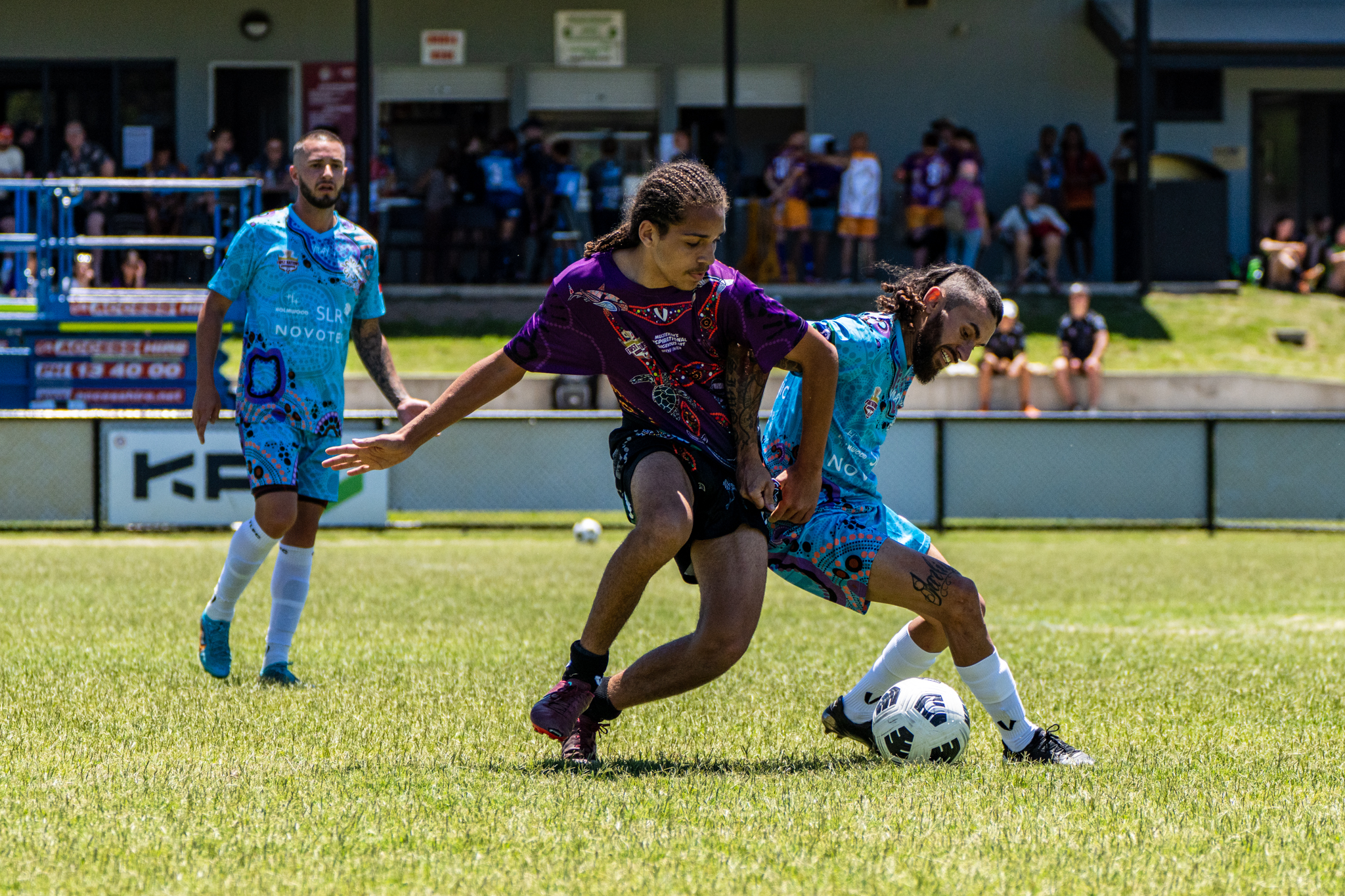 Footballers competing for possession during a local match