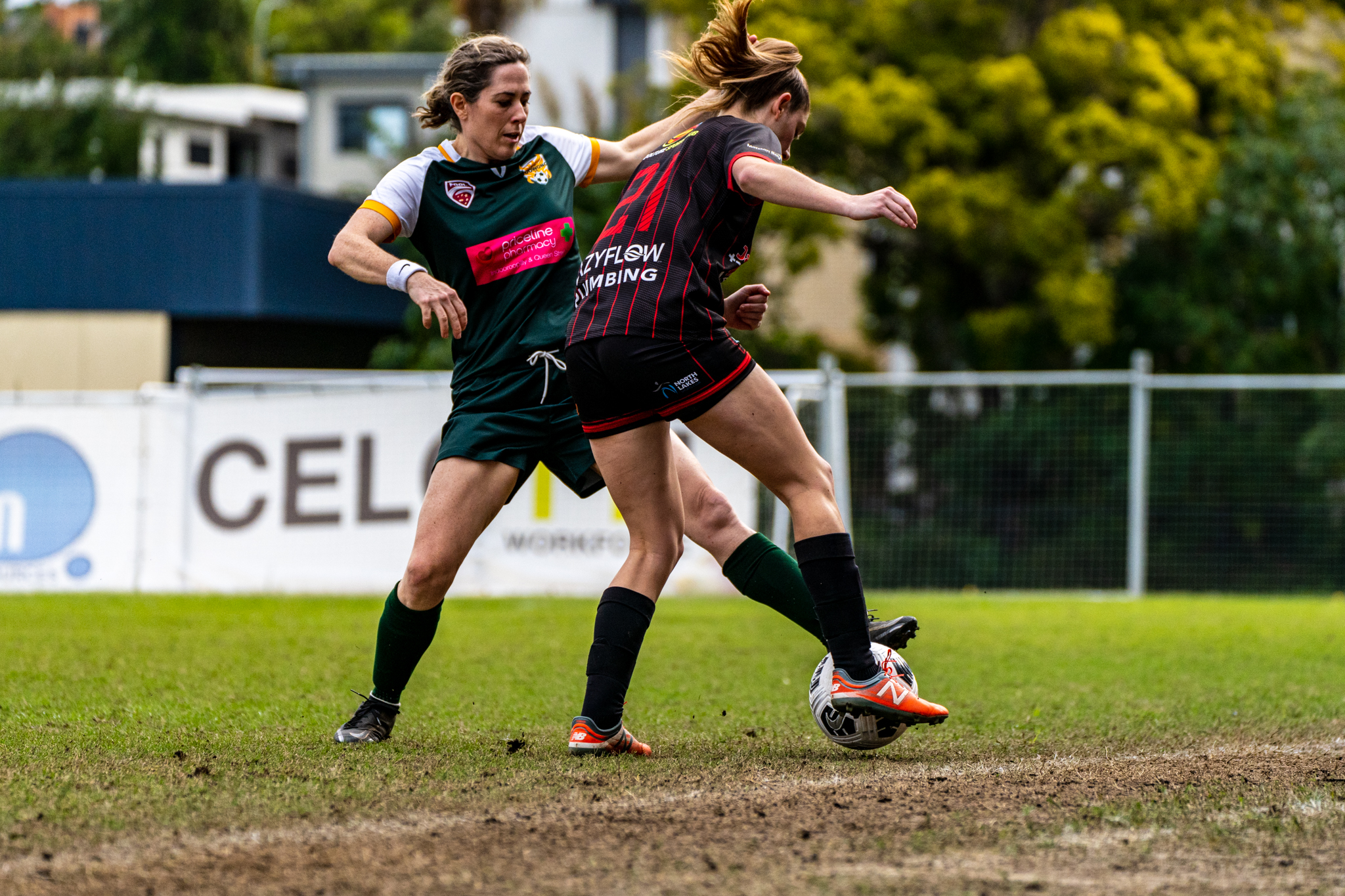 Two women footballers battling for the ball
