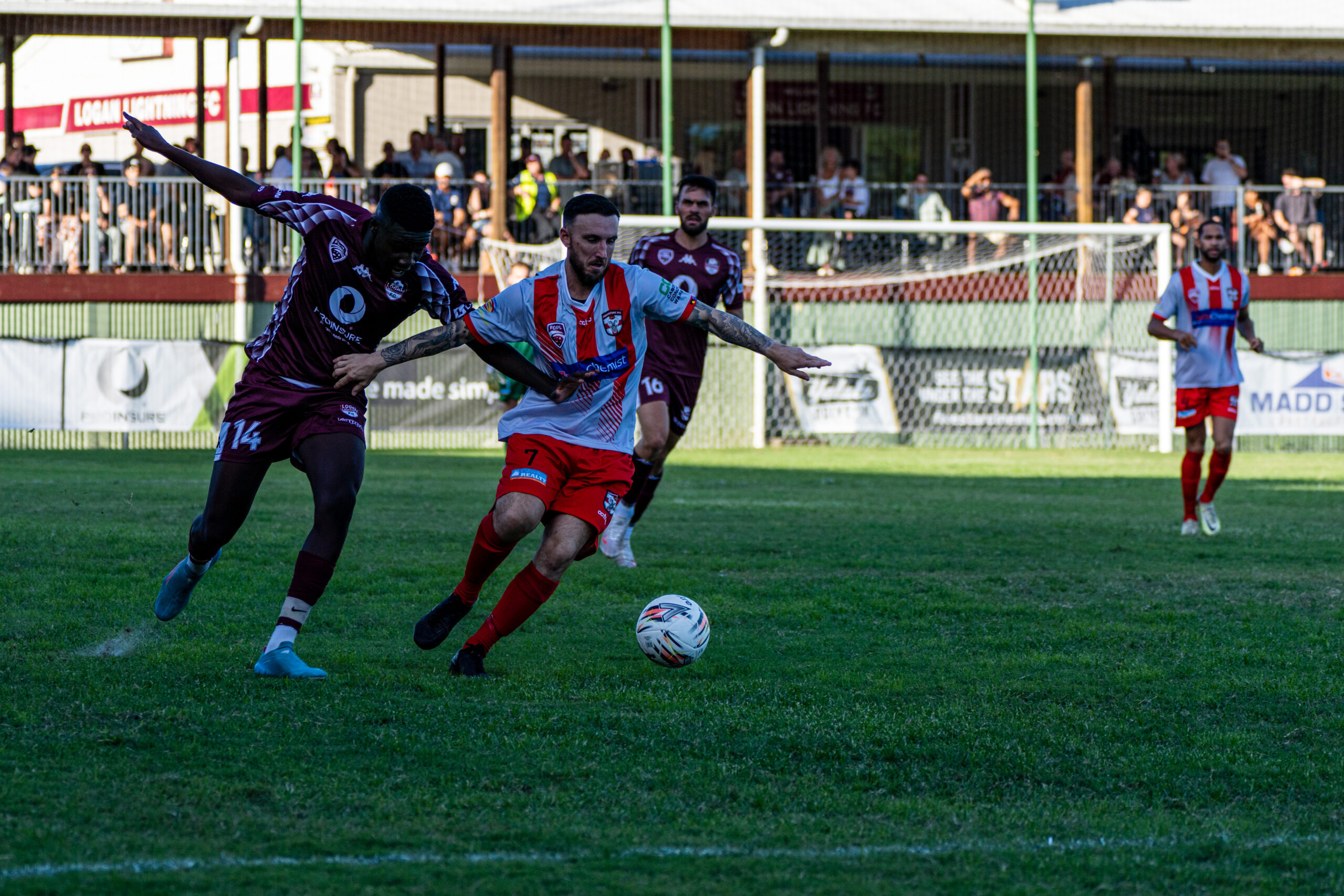 Two footballers chasing the ball during a local match