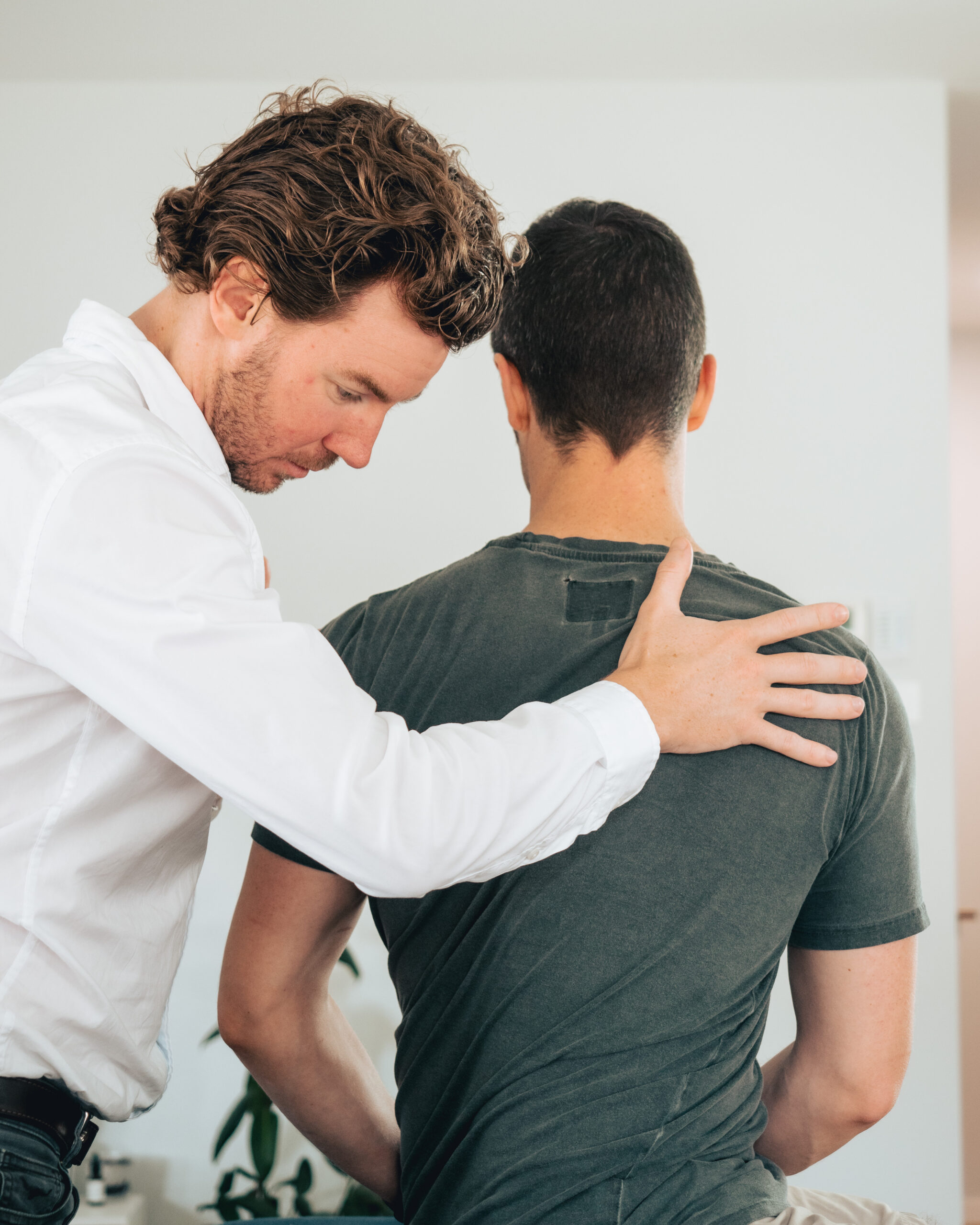 Physiotherapist assessing a client's shoulder and upper back posture