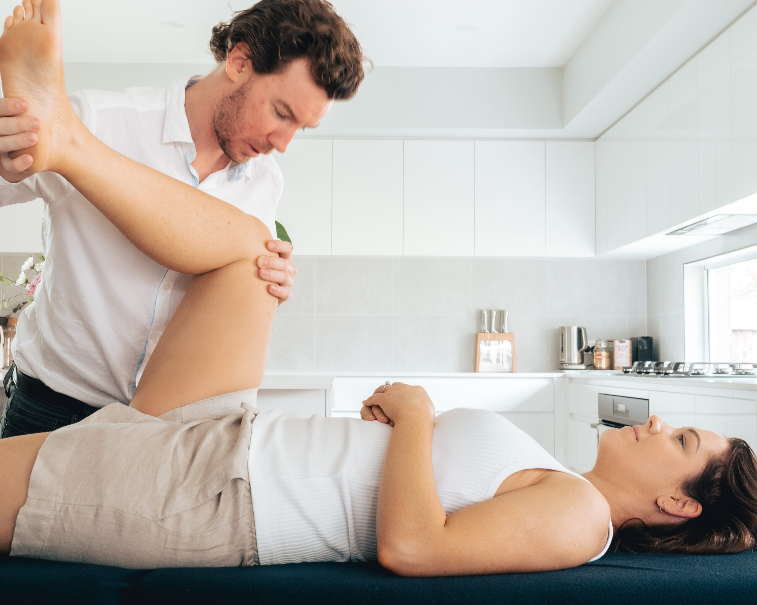 A woman receives a leg massage from a physio.