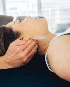 Physiotherapist releasing the muscles of a client's neck